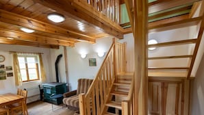Un interior de madera con una escalera, una zona de comedor y un radiador.