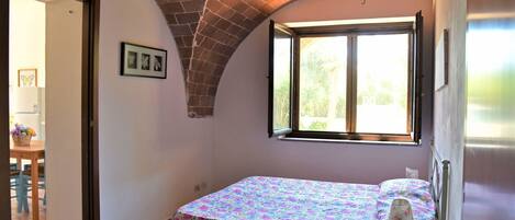 Ein Schlafzimmer mit einem Bett, einem Fenster und einem Deckenventilator.