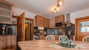 Una cocina moderna con armarios de madera, una isla grande y un comedor con sillas.