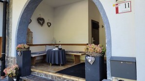 A stone archway leading to a seating area with a table and chairs, a mailbox, and a door with a number sign. - Lovely apartment for 5 guests with WIFI, TV, terrace and pets allowed (Ischgl)