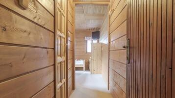Un couloir en bois, doté d’un sol recouvert de moquette et d’une porte au fond.