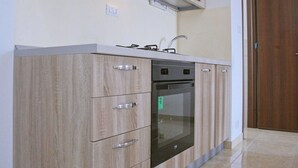 Een moderne keuken met houten keukenkastjes, een inbouwoven en een vaatwasser.