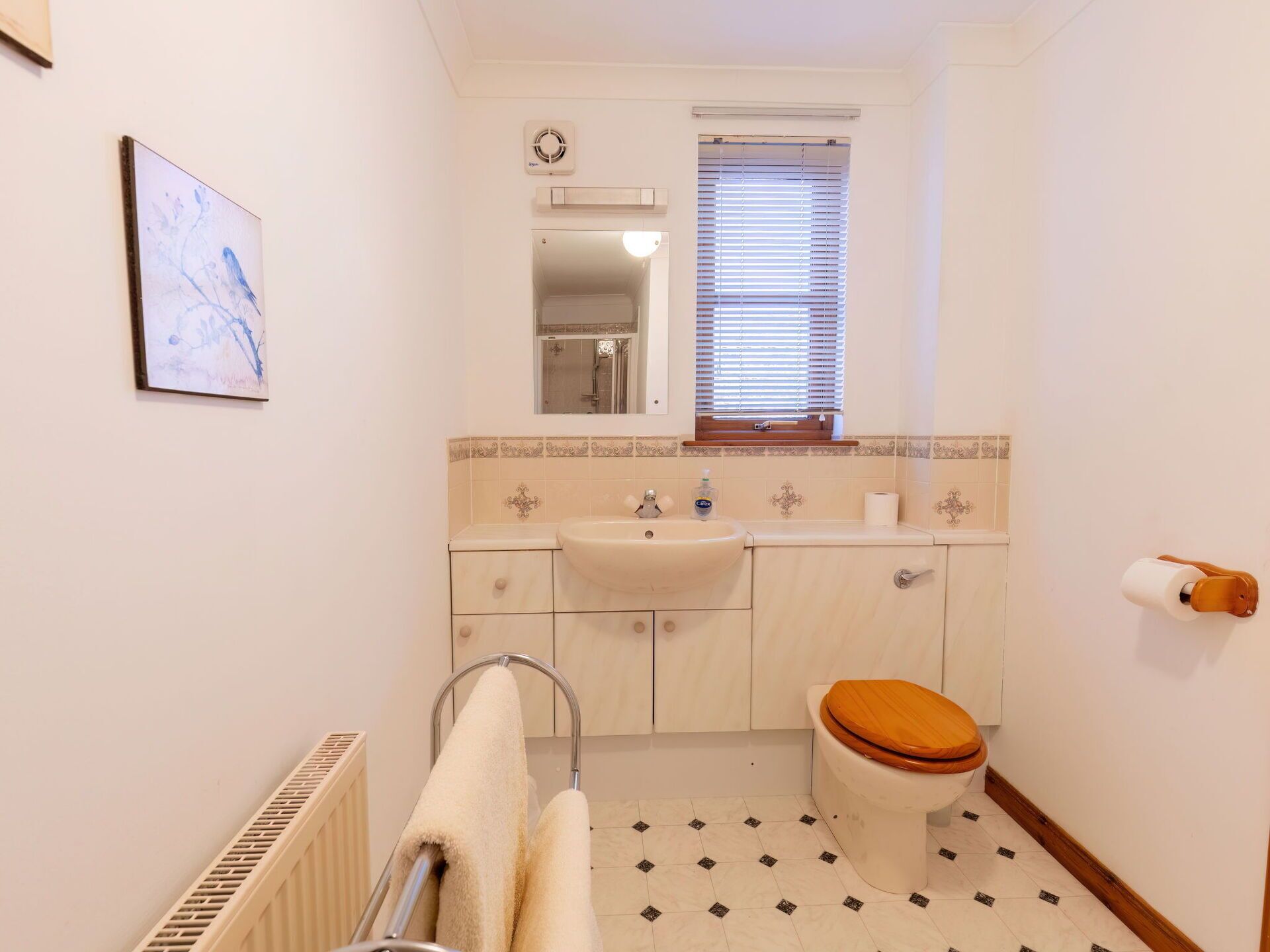 A bathroom with a toilet, sink, and shower.
