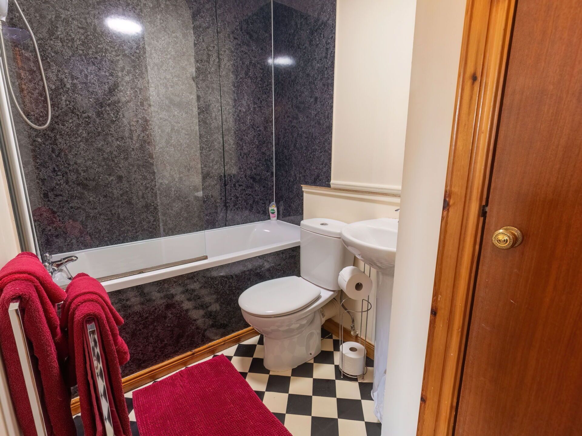 A bathroom with a shower, toilet, and sink.