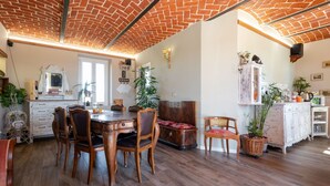 A dining area with a brick ceiling, wooden dining table, and chairs. - Stunning  villa for 10 people with A/C, private pool, WIFI and patio (San Damiano D'asti)