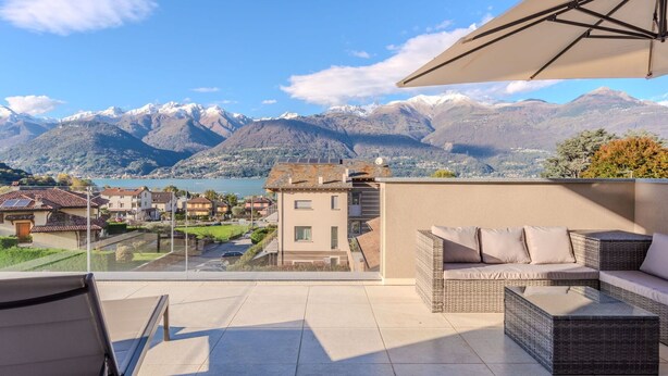 A terrace with a view of mountains and a lake, furnished with wicker furniture and a table. - Stunning private villa for 10 guests with A/C, WIFI, private pool, terrace and pets allowed (Colico)