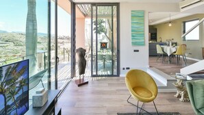 A modern interior with a large glass door leading to a balcony, a dining area, and a kitchen. - Beautiful private villa for 6 people with A/C, WIFI, pool, TV, patio and pets allowed (Maspalomas)