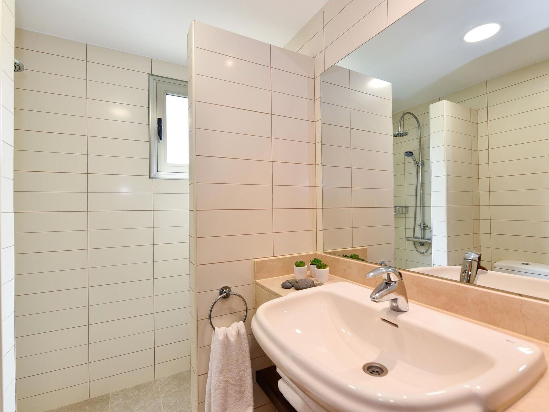 Une salle de bain moderne avec un grand miroir, deux lavabos et un espace douche.