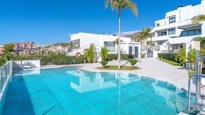 A modern hotel with a swimming pool, palm trees, and a view of other buildings. - Stunning  villa for 6 guests with WIFI, pool, A/C, TV and terrace (Nerja)