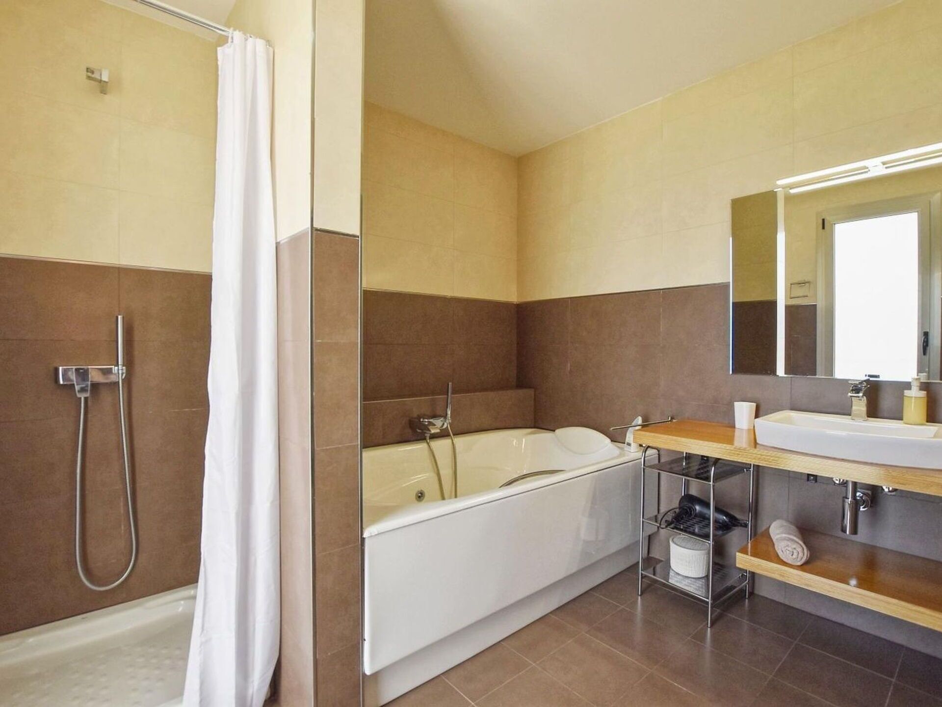Een moderne badkamer met douche, bad en wastafel.