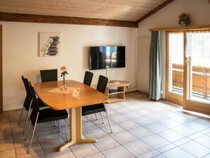 Relax in this stylish room with a large table, flat-screen TV, and sliding door to an outdoor area.