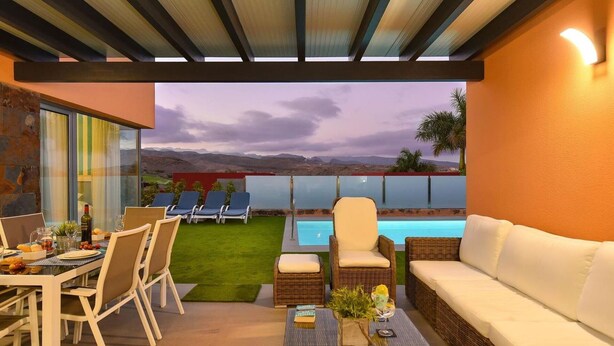 A modern outdoor lounge area with a pool, seating, and a dining setup.