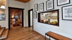 A hallway with wooden flooring, framed artwork on the walls, and a window overlooking a kitchen area. - Beautiful private villa for 10 guests with WIFI, private pool, TV and patio (Arucas)