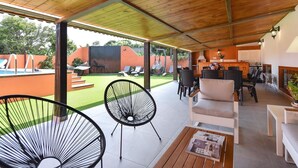 A covered outdoor living area with a pool, lounge chairs, and a dining area. - Beautiful private villa for 10 guests with WIFI, private pool, TV and patio (Arucas)