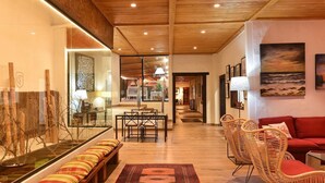 A spacious living area with a wooden ceiling, a dining area with a glass table, a red sofa, and a view of the kitchen in the background. - Beautiful private villa for 10 guests with WIFI, private pool, TV and patio (Arucas)