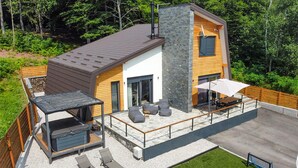 A modern house with a patio, outdoor seating, and a barbecue area. - Amazing home in Rizvanusa (Gospic)
