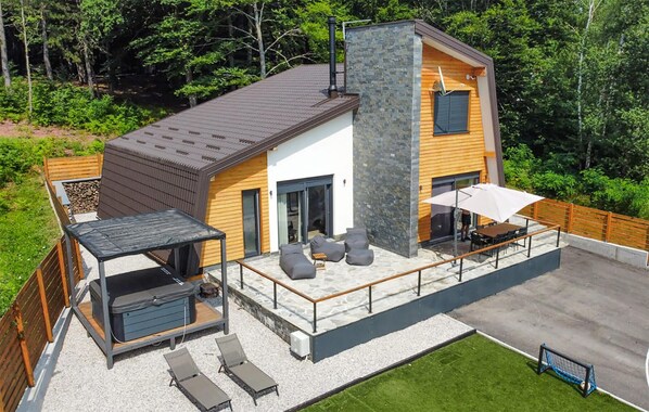 Enjoy a spacious patio with barbecue area, outdoor seating, and lawn, plus a large deck with covered patio and table.