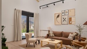 A modern living room with a brown sofa, a wooden coffee table, and a large window with curtains. - Amazing home in Rizvanusa (Gospic)