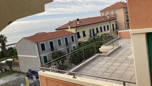 Un immeuble résidentiel avec un toit recouvert de tuiles, de nombreuses fenêtres et un balcon.