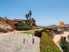 Set amidst a serene garden with lush greenery, this building offers a tranquil retreat with ample natural light and a scenic view of the surrounding hills.