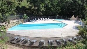 Une piscine dotée de nombreuses chaises longues et d’un espace détente séparé.