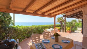 A covered outdoor dining area with a table set for four, overlooking the sea. - Wonderful private villa for 4 guests with A/C, WIFI, TV, terrace and pets allowed (Syracuse)