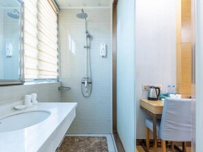 A bathroom with a sink, mirror, shower, and a small table with a chair. - Greentree Inn Hefei Government Cultural District South District Provincial Hospital Nanqu Hotel (Hefei)