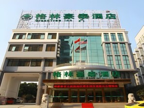 A hotel with a modern facade, featuring a prominent green logo and signage. - Greentree Inn Hefei Government Cultural District South District Provincial Hospital Nanqu Hotel (Hefei)