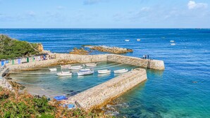 A coastal harbor with boats docked, a stone pier, and clear blue water. - Beautiful home in l'étang-bertrand (L'Étang-Bertrand)