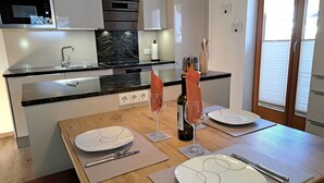 A modern kitchen with a dining area set for a meal. - Cosy apartment for 4 people with WIFI, TV and balcony (Grossdornau)