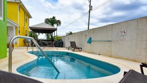 A swimming pool with a metal ladder, lounge chairs, and a covered area with a grill. - Prospect #1 - by Zenbreak (Prospect)