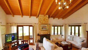 A spacious living room with a fireplace, a television, and a dining area with a table and chairs. - Wonderful private villa for 6 guests with WIFI, private pool, TV, patio and panoramic view (Inca)