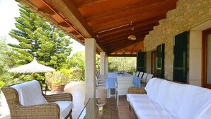 A covered outdoor seating area with wicker furniture, a table, and a large umbrella. - Wonderful private villa for 6 guests with WIFI, private pool, TV, patio and panoramic view (Inca)