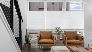 Un salon moderne avec deux fauteuils en cuir, une petite table et une plante en pot.