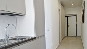 A modern kitchen with a stainless steel sink and a black range hood. - Nice apartment for 6 guests with A/C, TV, balcony and pets allowed (Formia)