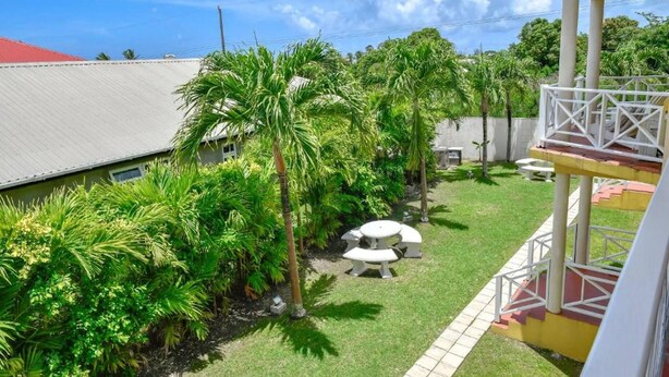 A courtyard with a white table and chairs, surrounded by lush greenery and palm trees. - Prospect #2 - by Zenbreak (Prospect)