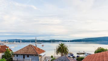 Un pueblo costero con un puerto deportivo, barcos y una vista despejada del mar.