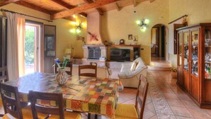 A cozy dining area with a wooden ceiling, a fireplace, and a dining table with chairs. - Beautiful private villa with private pool, A/C, WIFI, TV, patio, pets allowed and panoramic view (Solarino)