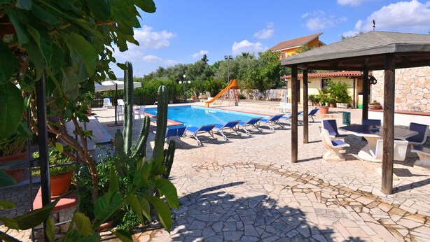 A pool area with lounge chairs, a children's play structure, and potted plants. - Beautiful private villa with private pool, A/C, WIFI, TV, patio, pets allowed and panoramic view (Solarino)