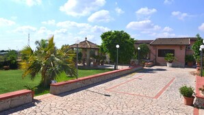 A courtyard with a tiled floor, a pergola, and a building with a tiled roof. - Beautiful private villa with private pool, A/C, WIFI, TV, patio, pets allowed and panoramic view (Solarino)