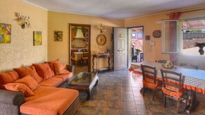 Ein Wohnzimmer mit Sofa, Couchtisch und Essbereich mit Stühlen und Tisch.