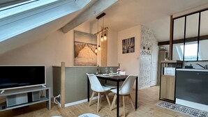 Une chambre moderne de style loft, comprenant un coin repas, une cuisine et un téléviseur.