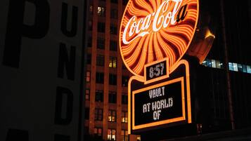 A building with a large Coca-Cola sign and a digital display reading "Vault at World of".