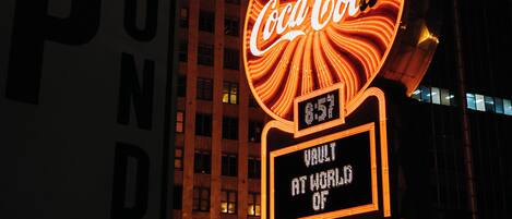 A building with a large Coca-Cola sign and a digital display reading "Vault at World of".