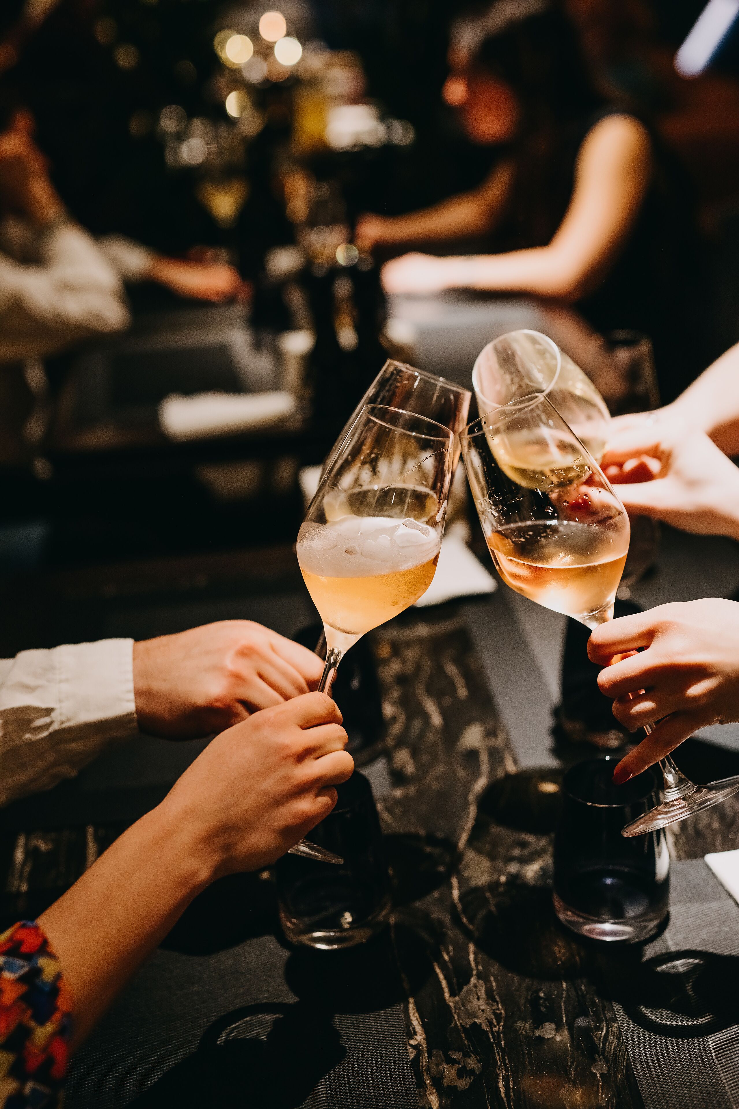 A group of people toasting with champagne glasses at a table.