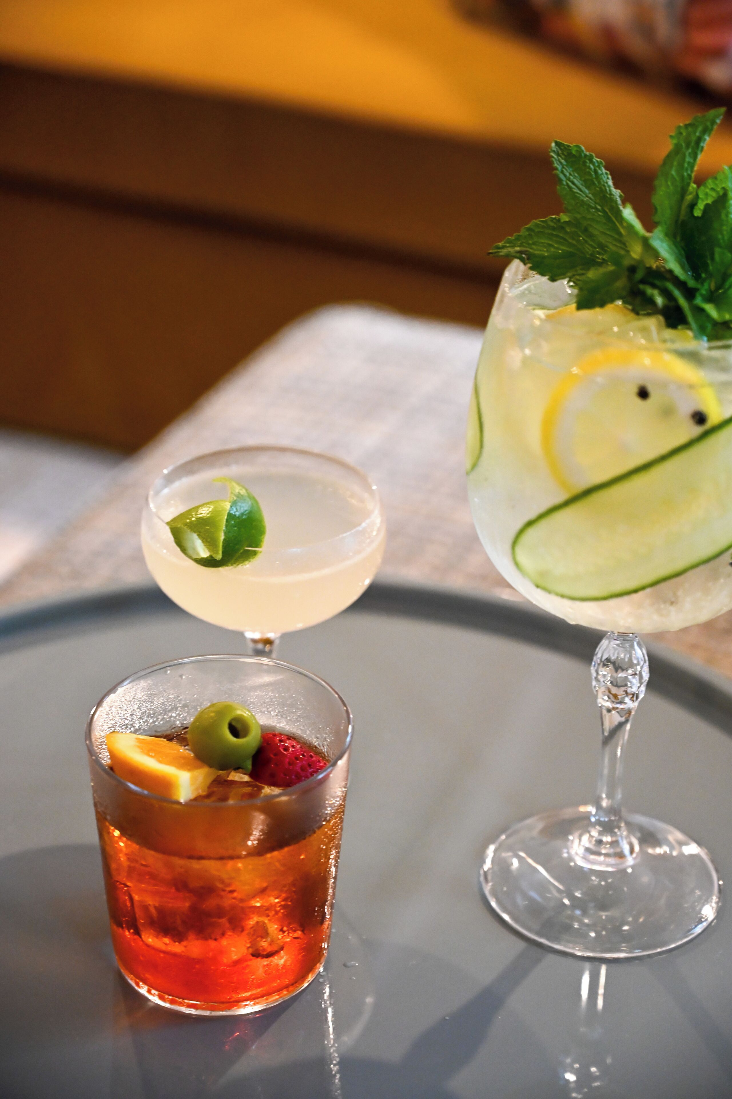 Two cocktails on a table with a blurred background.