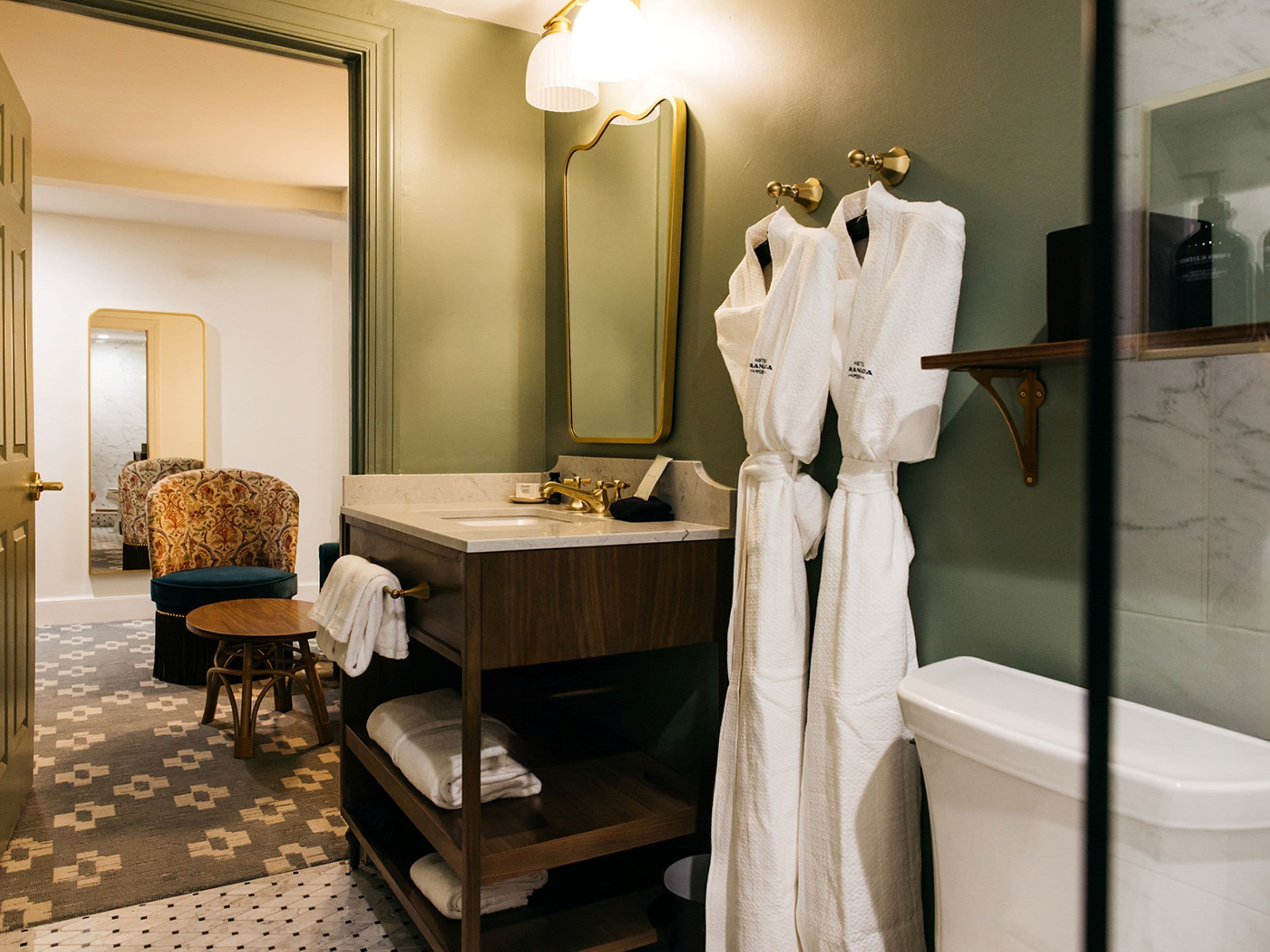 A bathroom with a vanity, a mirror, a bathtub, and a towel rack.