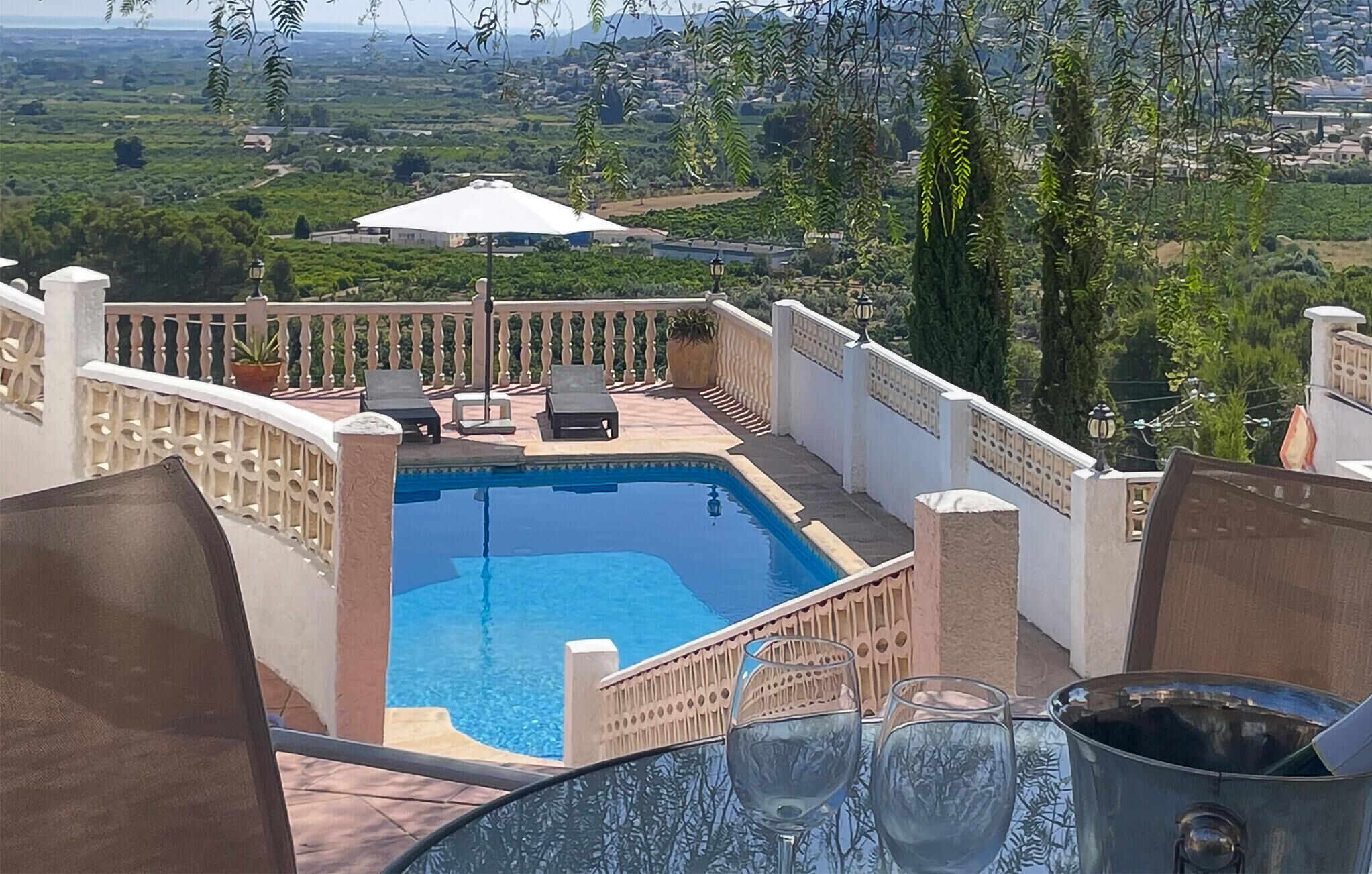 A pool area with a view of a landscape, including houses and trees.