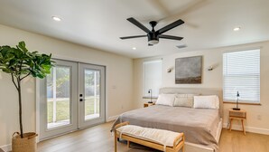 A bedroom with a bed, a bench, a ceiling fan, a window, and a plant. - Naples Duplex Home w/ Private Pool & Lanai! (Naples)
