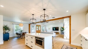 A spacious kitchen with a central island, wooden beams, and pendant lighting. - Naples Duplex Home w/ Private Pool & Lanai! (Naples)